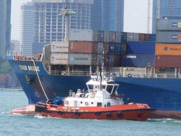 Containerschiff mit Schlepper